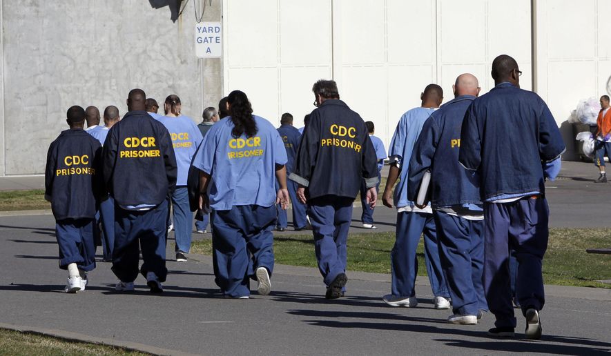 FILE - In this Feb. 26, 2013, file photo, inmates walk through the exercise yard at California State Prison Sacramento, near Folsom, Calif. California arrest rates have dropped nearly 60 percent since 1989, yet blacks are three times more likely to be arrested than whites, according to a report released by the Public Institute of California, Monday Dec. 3, 2018. (AP Photo/Rich Pedroncelli, File)