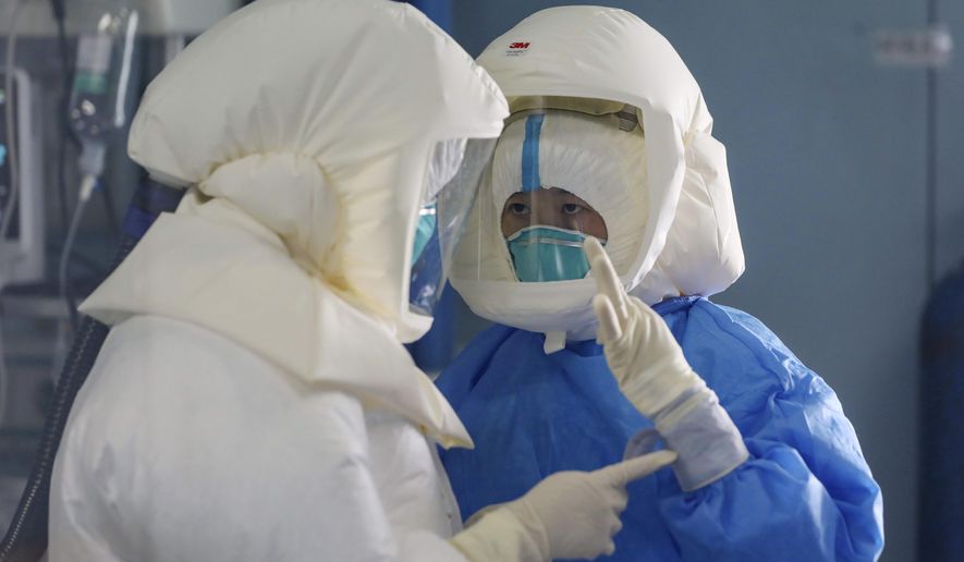 Medical staff work in the negative-pressure isolation ward in Jinyintan Hospital, designated for critical COVID-19 patients, in Wuhan in central China's Hubei province Thursday, Feb. 13, 2020. China on Thursday reported 254 new deaths and a spike in virus cases of 15,152, after the hardest-hit province of Hubei applied a new classification system that broadens the scope of diagnoses for the outbreak, which has spread to more than 20 countries. (Chinatopix Via AP)
