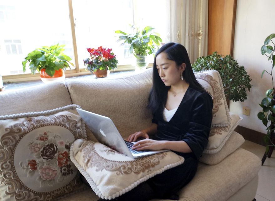 In this Wednesday, Feb. 12, 2020, photo released by Maggie Zhang, Zhang uses a laptop computer at her parents&#x27; home in in the northwestern city of Zhangye in Gansu province. Zhang, founder of SheTalks, a company in Beijing that organizes events for women, is working out of her parents&#x27; apartment after she went back for the Lunar New Year and said she might stay through March. (Maggie Zhang via AP)
