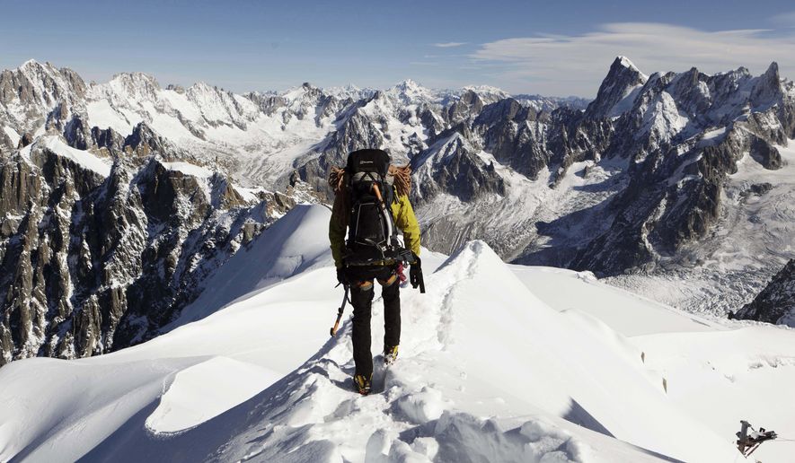 In this file photo taken on Oct. 12, 2011, an alpinist heads down a ridge on the Aiguille du Midi (3,842 meters; 12 605 feet), towards the Vallee Blanche on the Mont Blanc massif, in the Alps, near Chamonix. Climbers aiming to summit Mont Blanc, the tallest peak in the Alps, will now have to pre-pay over $15,000 to cover potential rescue and funeral costs in the French town of Saint-Gervais-les-Bains at the foot of the storied European peak. (AP Photo/David Azia,File) **FILE**