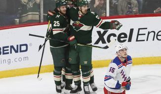 Minnesota Wild&#39;s Jonas Brodin,left, is congratulated by teammates after scoring against the New York Rangers during the first period of an NHL hockey game Thursday, Feb. 13, 2020, in St. Paul, Minn. Watching the scoreboard is Rangers&#39; Ryan Lindgren. (AP Photo/Jim Mone)