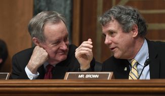 Senate Banking Committee Chairman Sen. Mike Crapo, R-Idaho, left, talks with ranking member Sen. Sherrod Brown, D-Ohio, right, during a hearing with Federal Reserve Chairman Jerome Powell on Capitol Hill in Washington, Wednesday, Feb. 12, 2020. (AP Photo/Susan Walsh)