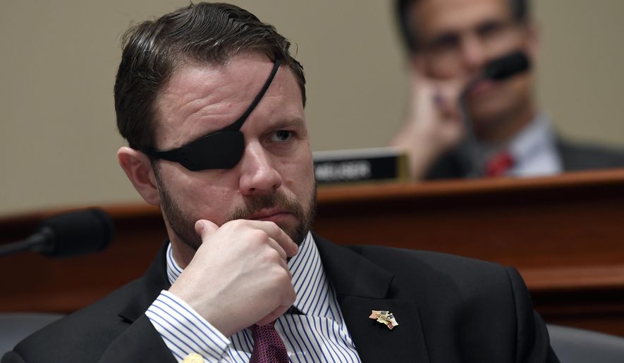 In this Tuesday, March 12, 2019, file photo, U.S. Rep. Dan Crenshaw, R-Texas, left, listens as Office of Management and Budget Acting Director Russell Vought testifies before the House Budget Committee on Capitol Hill in Washington, during a hearing on the fiscal year 2020 budget. (AP Photo/Susan Walsh, File)