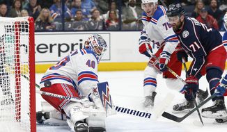 New York Rangers&#39; Alexandar Georgiev, left, makes a save as Brady Skjei, center, and Columbus Blue Jackets&#39; Nick Foligno watch the puck during the second period of an NHL hockey game Friday, Feb. 14, 2020, in Columbus, Ohio. (AP Photo/Jay LaPrete)