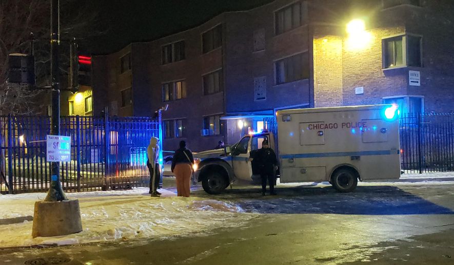 Emergency responders work the scene of a shooting late Friday, Feb. 14, 2020 in Chicago. Six people, including three minors, were wounded in a shooting at an apartment complex on Chicago's South Side, police said.The Friday night shooting started during a “gathering” inside an apartment unit and spilled into the hall, police said in a release early Saturday. (Nader Issa/Chicago Sun-Times via AP)