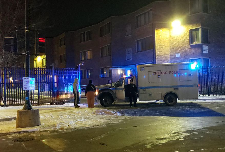 Emergency responders work the scene of a shooting late Friday, Feb. 14, 2020 in Chicago. Six people, including three minors, were wounded in a shooting at an apartment complex on Chicago's South Side, police said.The Friday night shooting started during a “gathering” inside an apartment unit and spilled into the hall, police said in a release early Saturday. (Nader Issa/Chicago Sun-Times via AP)