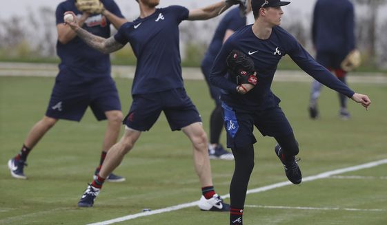 Atlanta Braves pitchers, from left, Shane Greene, Mike Foltynewicz and Max Fried loosen up at spring training baseball camp in North Port, Fla., Wednesday, Feb. 12, 2020. (Curtis Compton/Atlanta Journal-Constitution via AP)