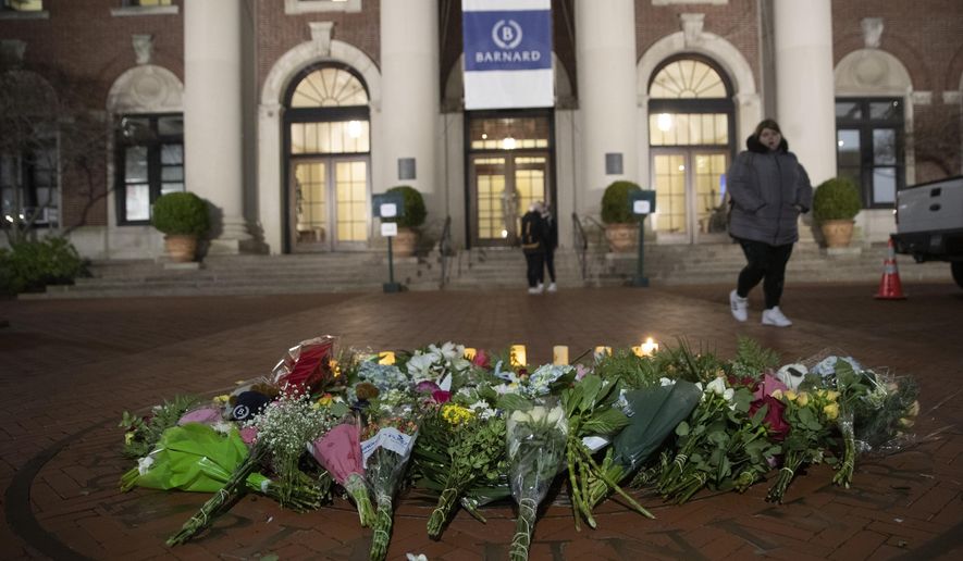 FILE - In this Dec. 12, 2019 file photo, a woman walks past a make-shift memorial for Tessa Majors inside the Barnard College campus in New York.  Authorities say a 14-year-old was arrested in fatal stabbing of Majors on Saturday, Feb. 15, 2020.  Majors was stabbed as she walked through Manhattan’s Morningside Park on Dec. 11.   (AP Photo/Mary Altaffer, File)