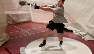 In this Tuesday, Feb. 11, 2020 photo, Northern State University&#39;s Tanner Berg works on his weight throw technique during practice at the Barnett Center in Aberdeen, S.D. (John Davis/Aberdeen American News via AP)