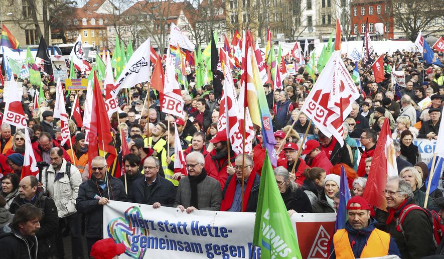 Demonstrators attend a rally against the ousting of a popular governor by a far-right and two centrist parties in Erfurt, Germany, Saturday, Feb. 15, 2020. The politician Thomas Kemmerich was elected as Thuringian Prime Minister with votes of the far-right Alternative fuer Deutschland (AfD) party. The poster reads: Heart instead of agitation - together against the right. (Bodo Schackow/dpa via AP)