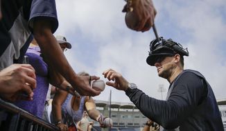 New York Yankees manager Aaron Boone signs autographs during a spring training baseball workout Thursday, Feb. 13, 2020, in Tampa, Fla. (AP Photo/Frank Franklin II)