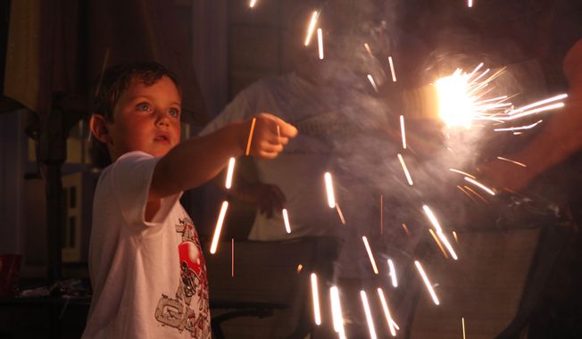 Nate Murray, 4, holds a sparkler at a home in Scarborough, Maine, Wednesday, July 4, 2012. This Independence Day is the first since 1949 that fireworks have been legal in Maine. Since fireworks again became legal on Jan. 1, a dozen fireworks stores have opened from Scarborough in the south to Presque Isle in the north.  (AP Photo/Joel Page)