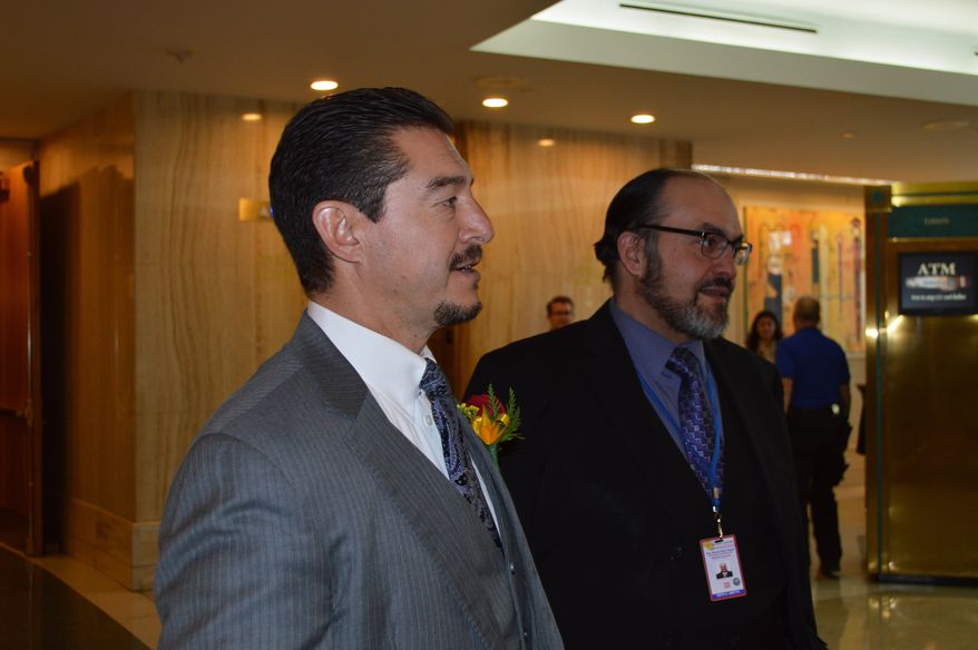 In this Jan. 21, 2020, photo, New Mexico Sen. John Sapien, D-Corrales, left, and his aide, Sisto Abeyta, right, greet visitors to the Capitol in Santa Fe, N.M., before the start of the Legislative Session. Sapien, a Democrat from a swing district, announced Sunday, Feb. 16, he would not seek re-election. (AP Photo/ Russell Contreras)