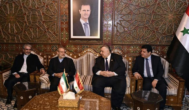 In this photo released by the Syrian official news agency SANA, Speaker of the People&#x27;s Council of Syria Hammouda Sabbagh, center right, receives Iran&#x27;s Parliament Speaker Ali Larijani, second left, on his arrival to the airport, in the Syrian capital Damascus, Sunday, Feb. 16, 2020. (SANA via AP)