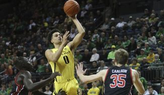 Oregon&#39;s Will Richardson, center, shoots between Utah&#39;s Both Gach, left, and Branden Carlson during the first half of an NCAA college basketball game in Eugene, Ore., Sunday, Feb. 16, 2020. (AP Photo/Chris Pietsch)