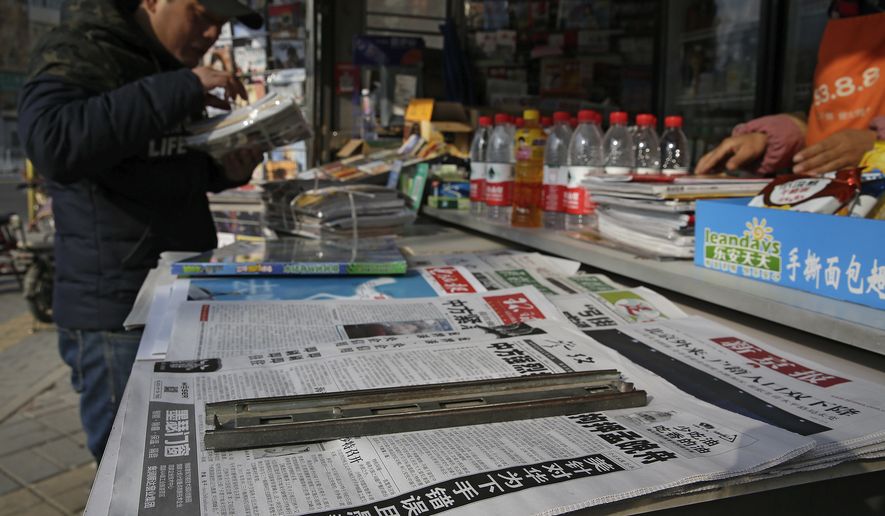 A man arranges magazines near newspapers at a newsstand in Beijing, Monday, Dec. 10, 2018. (AP Photo/Andy Wong) **FILE**
