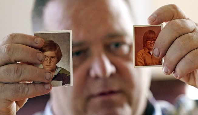 In this Thursday, Feb. 13, 2020, photo, James Kretschmer holds photographs of himself at age 11 and 12 during an interview in Houston. The Boy Scouts of America has filed for bankruptcy protection as it faces a barrage of new sex-abuse lawsuits. The filing Tuesday, Feb. 18, in Wilmington, Del., is an attempt to work out a potentially mammoth compensation plan for abuse victims that will allow the 110-year-old organization to carry on. Kretschmer of Houston, among the many men suing for alleged abuse, says he was molested by a Scout leader over several months in the mid-1970s in the Spokane, Washington, area. (AP Photo/David J. Phillip)