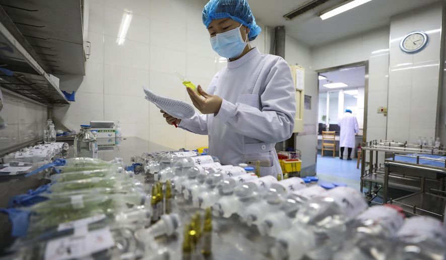 In this Sunday, Feb. 16, 2020, photo, a nurse prepares medicines for patients at Jinyintan Hospital designated for new coronavirus infected patients, in Wuhan in central China's Hubei province. China reported thousands new virus cases and more deaths in its update Tuesday, Feb. 18, 2020 on a disease outbreak that has caused milder illness in most people, an assessment that promoted guarded optimism from global health authorities. (Chinatopix via AP)