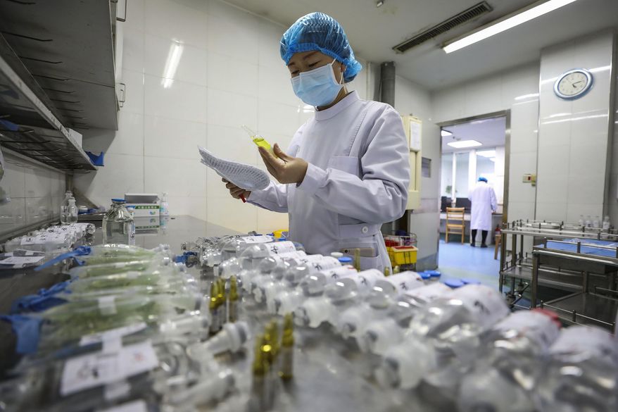 In this Sunday, Feb. 16, 2020, photo, a nurse prepares medicines for patients at Jinyintan Hospital designated for new coronavirus infected patients, in Wuhan in central China's Hubei province. China reported thousands new virus cases and more deaths in its update Tuesday, Feb. 18, 2020 on a disease outbreak that has caused milder illness in most people, an assessment that promoted guarded optimism from global health authorities. (Chinatopix via AP)
