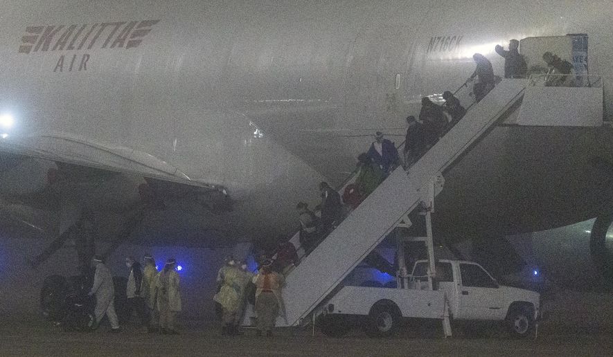 American passengers evacuated from a cruise ship in Japan disembark from a Kalitta Air flight at Kelly Field, early Monday, Feb. 17, 2020 in San Antonio, Texas.  The U.S. said it arranged the evacuation because people on the Diamond Princess were at a high risk of exposure to the new virus that&#39;s been spreading in Asia. For the departing Americans, the evacuation cuts short a 14-day quarantine that began aboard the cruise ship Feb. 5.   (William Luther /The San Antonio Express-News via AP)