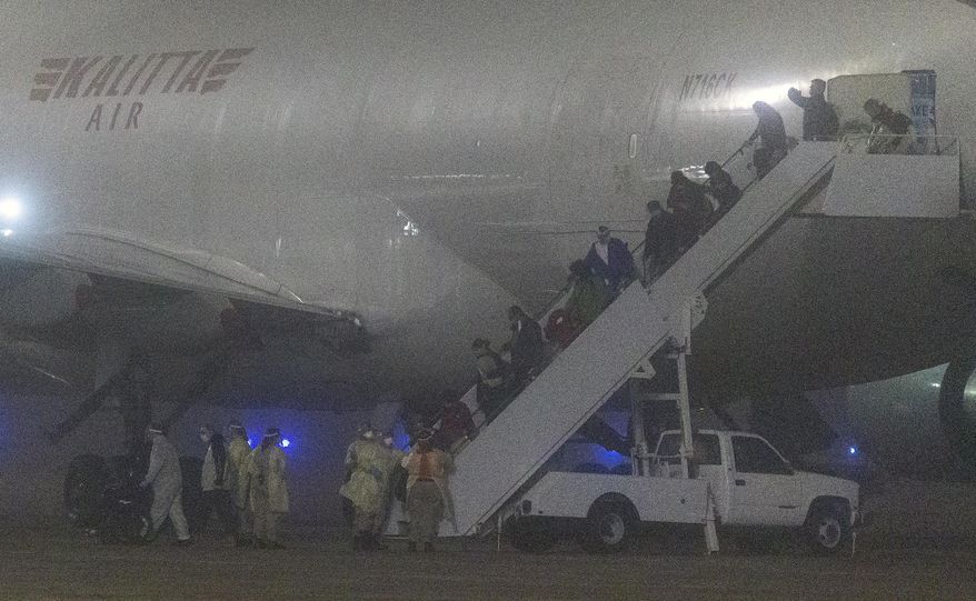 American passengers evacuated from a cruise ship in Japan disembark from a Kalitta Air flight at Kelly Field, early Monday, Feb. 17, 2020 in San Antonio, Texas.  The U.S. said it arranged the evacuation because people on the Diamond Princess were at a high risk of exposure to the new virus that&#39;s been spreading in Asia. For the departing Americans, the evacuation cuts short a 14-day quarantine that began aboard the cruise ship Feb. 5.   (William Luther /The San Antonio Express-News via AP)
