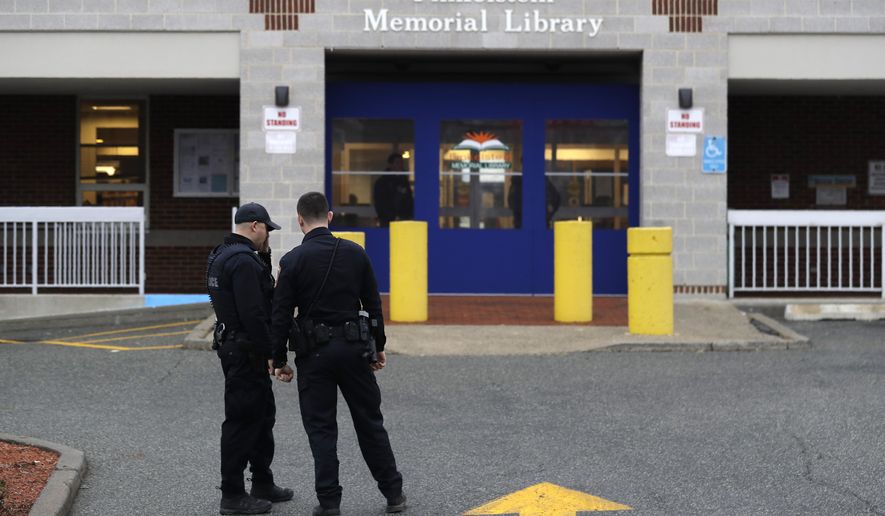 Policemen stand in front of the Finkelstein Memorial Library in Spring Valley, N.Y., Tuesday, Feb. 18, 2020. A female security guard was fatally stabbed on the third floor of the library Tuesday afternoon in a chaotic scene that ended when patrons gang-tackled the suspect until police could take him into custody, the Journal News reported. (AP Photo/Seth Wenig)
