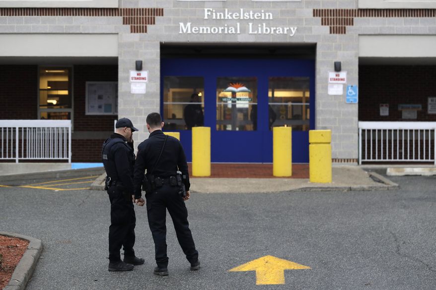 Policemen stand in front of the Finkelstein Memorial Library in Spring Valley, N.Y., Tuesday, Feb. 18, 2020. A female security guard was fatally stabbed on the third floor of the library Tuesday afternoon in a chaotic scene that ended when patrons gang-tackled the suspect until police could take him into custody, the Journal News reported. (AP Photo/Seth Wenig)