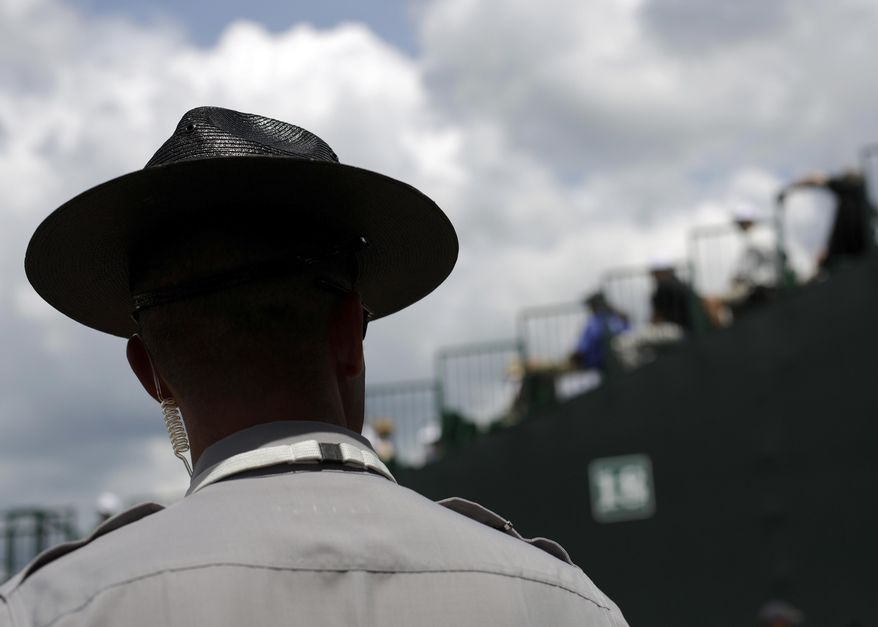 FILE - In this Thursday, June 12, 2014 file photo, a North Carolina State Trooper stands guard during the U.S. Open golf tournament in Pinehurst, N.C. On Tuesday, Feb. 18, 2020, an appeals court ruled that a former Trooper Thomas Wetherington shouldn't have been fired for losing his hat in 2009 and lying about it in a case that's spanned a decade and multiple trips through the courts. (AP Photo/David Goldman)