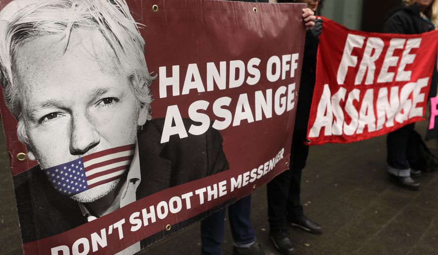 Demonstrators hold banners outside Westminster Magistrates Court in London, Wednesday, Feb. 19, 2020. A case-management hearing regarding Julian Assange will be heard at the court Wednesday. (AP Photo/Kirsty Wigglesworth)