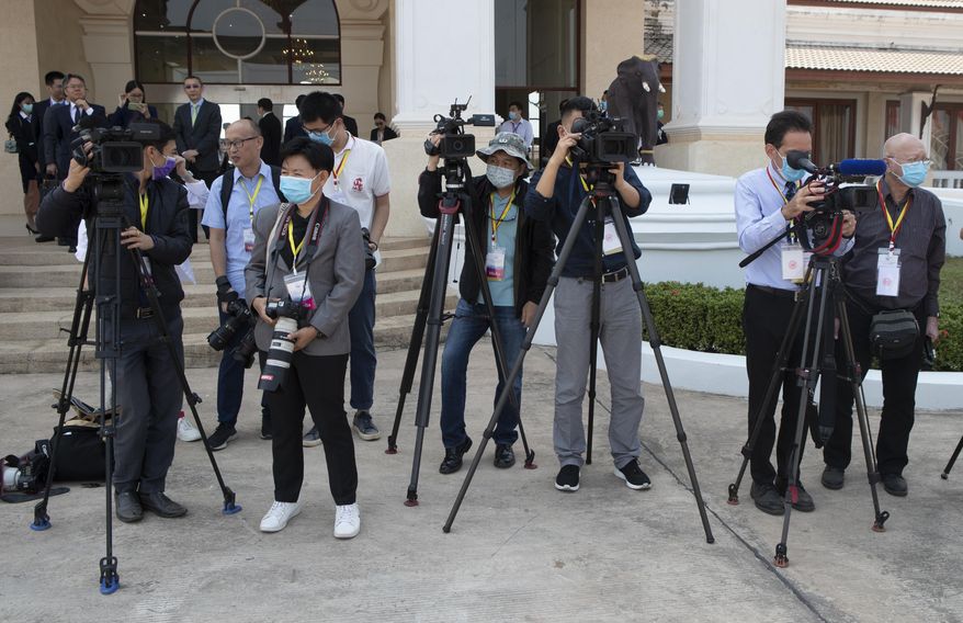 Media wear face masks to protect themselves from a new virus wait China&#39;s Foreign Minister Wang Yi&#39;s arrival at Wattay Airport for the Special ASEAN-China Foreign Ministers&#39; Meeting on the coronavirus disease 2019 (COVID-19) in Vientiane, Laos, Wednesday, Feb. 19, 2020. (AP Photo/Sakchai Lalit)