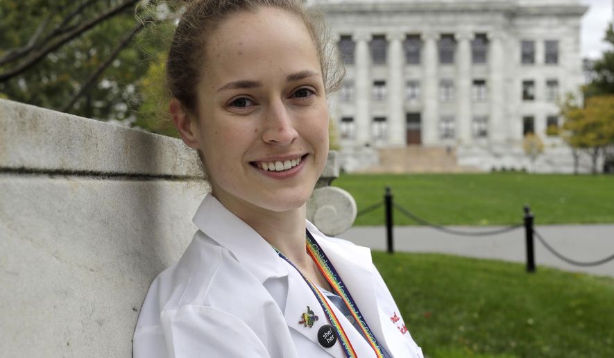 In this Thursday, Oct. 17, 2019 photo Harvard Medical School student Aliya Feroe, of Minneapolis, Minn., poses for a photograph on the school's campus, in Boston. Feroe recalls a flustered OB-GYN who referred her to another physician after learning she identified as queer. Medical schools are beefing up education on LBGTQ health issues. And some schools are making a big push to recruit LGBTQ medical students, backed by research showing that patients often get better care when treated by doctors who are more like them. (AP Photo/Steven Senne)