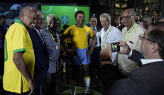 Former Brazilian soccer legends, from left, Dario, Rogerio Caboclo (the president of the Brazilian Football Confederation ), Edu, Clodoaldo and Brito. pose for a photo with a statue of soccer legend Pele at the Brazilian Soccer Team Museum in Rio de Janeiro, Brazil, Thursday, Feb. 20, 2020. The Brazilian Football Confederation unveiled the statue as part of commemorations of 50 years since the World Cup victory in 1970. (AP Photo/Leo Correa)