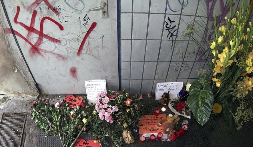 FILE - In this file photo dated Thursday, Aug. 3, 2000, flowers and candle tributes at a memorial beside the scene of an explosion that took place last Thursday, in Duesseldorf, Germany. A bomb explosion at a commuter train station on Thursday July 27 injured many, two of them seriously and unborn child died. In a deadly shooting late Wednesday Feb. 19, 2020, German authorities suspect that the gunman who killed several people with migrant backgrounds in the Frankfurt suburb of Hanau was motivated by racism, the latest in a long line of far-right attacks in Germany, a country still grappling with its Nazi past. (AP Photo/Edgar R.Schoepal, FILE)