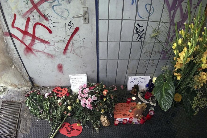 FILE - In this file photo dated Thursday, Aug. 3, 2000, flowers and candle tributes at a memorial beside the scene of an explosion that took place last Thursday, in Duesseldorf, Germany. A bomb explosion at a commuter train station on Thursday July 27 injured many, two of them seriously and unborn child died. In a deadly shooting late Wednesday Feb. 19, 2020, German authorities suspect that the gunman who killed several people with migrant backgrounds in the Frankfurt suburb of Hanau was motivated by racism, the latest in a long line of far-right attacks in Germany, a country still grappling with its Nazi past. (AP Photo/Edgar R.Schoepal, FILE)