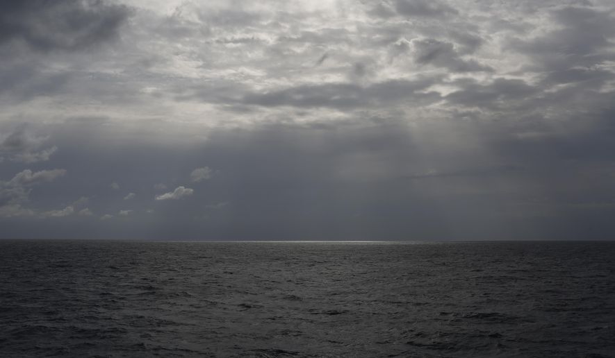 FILE -In this Sunday, Sept. 8, 2019 file photo the sun pierces the clouds over international waters north of Libya in the Mediterranean Sea.   A rubber dinghy packed with 91 migrants that set out from Libyan shores in hopes of reaching Europe has apparently gone missing in the Mediterranean, the U.N. refugee agency said Thursday, Feb. 20, 2020. The inflatable boat carrying mostly African migrants departed from al-Qarbouli, 50 kilometers (30 miles) east of the capital Tripoli on Feb. 8, said Osman Haroun, whose cousin was on board. He hasn’t heard from the 27-year-old Mohamed Idris, or his 10 other friends also on the boat, since. (AP Photo/Renata Brito, File)