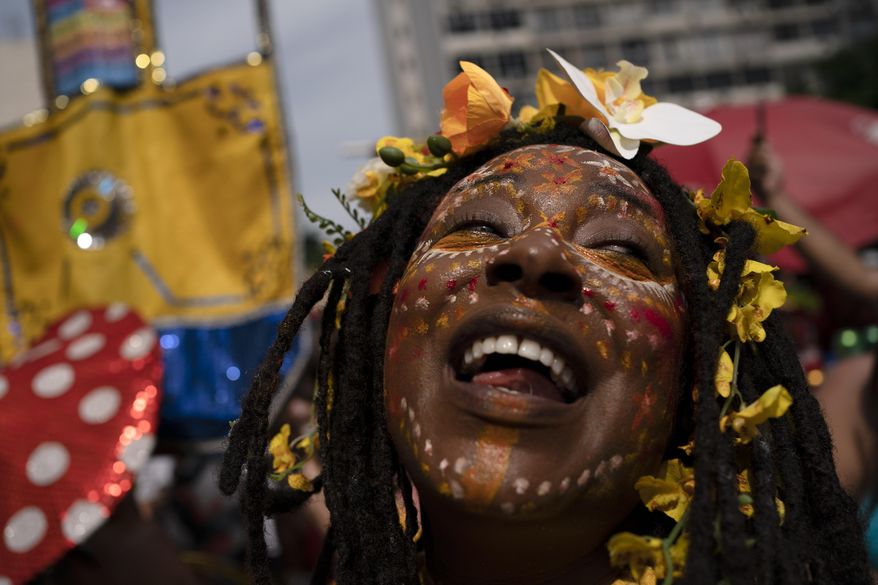 A reveler in a costume enjoys the "Cordao do Boitata" street party, one of the many parades before the start of Carnival which begins on Feb. 21, in Rio de Janeiro, Brazil, Sunday, Feb. 16, 2020. (AP Photo/Leo Correa)