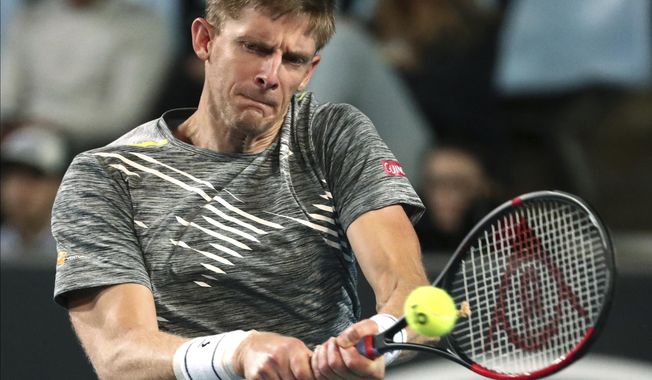 Kevin Anderson of South Africa makes a backhand return to Taylor Fritz of the U.S. during their second round singles match at the Australian Open tennis championship in Melbourne, Australia, Thursday, Jan. 23, 2020. (AP Photo/Dita Alangkara)