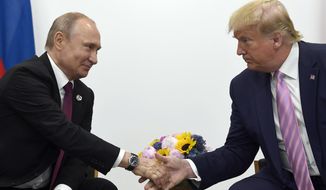 In this June 28, 2019, file photo, President Donald Trump, right, shakes hands with Russian President Vladimir Putin, left, during a bilateral meeting on the sidelines of the G-20 summit in Osaka, Japan. (AP Photo/Susan Walsh, File)