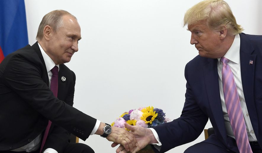 In this June 28, 2019, file photo, President Donald Trump, right, shakes hands with Russian President Vladimir Putin, left, during a bilateral meeting on the sidelines of the G-20 summit in Osaka, Japan. (AP Photo/Susan Walsh, File)
