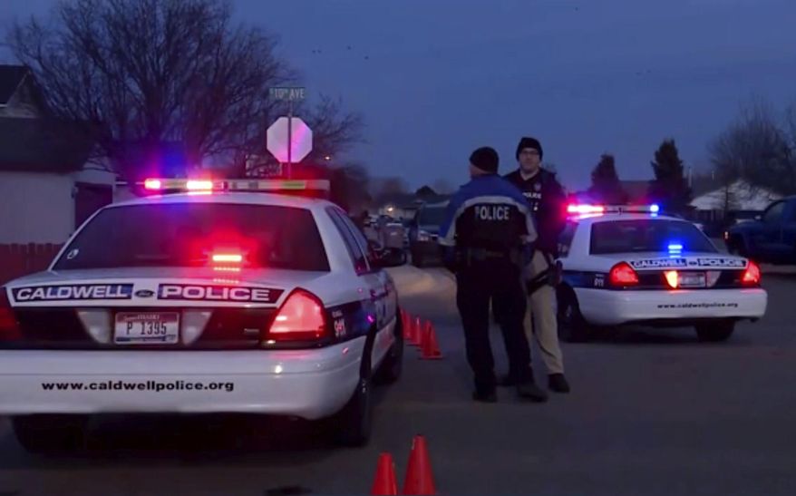In this image made from video, police cars and officers are seen near the site of a shooting in Caldwell, Idaho, Friday, Feb. 20, 2020. Idaho police say at least two people were killed and three were injured in a shooting at an apartment complex for senior citizens in Caldwell.(KBOI/CBS 2 via AP)