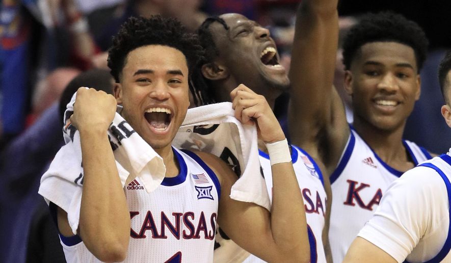Kansas guards Devon Dotson (1), Marcus Garrett (0) and Ochai Agbaji, right, celebrate a teammates basket during the second half of an NCAA college basketball game against Iowa State in Lawrence, Kan., Monday, Feb. 17, 2020. Dotson scored 29 points in the game. Kansas defeated Iowa State 91-71. (AP Photo/Orlin Wagner)