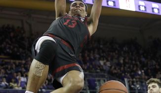 Stanford&#39;s Oscar da Silva hangs from the basket after dunking against Washington late in the second half of an NCAA college basketball game Thursday, Feb. 20, 2020, in Seattle. Stanford won 72-64. (AP Photo/Elaine Thompson)