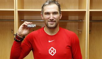 Washington Capitals&#39; Alex Ovechkin poses with the puck commemorating his 700th career NHL goal that he scored against the New Jersey Devils in the third period at Prudential Center on Saturday, Feb. 22, 2020, in Newark, New Jersey. (Patrick McDermott/NHLI Pool Photo via AP) ** FILE **