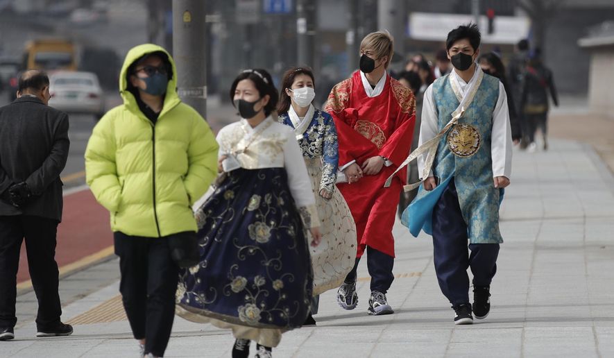 REMOVES REFERENCE TO NUMBER OF VIRAL INFECTIONS - Visitors wearing face masks walk near the Gwanghwamun, the main gate of the 14th-century Gyeongbok Palace, and one of South Korea&#x27;s well-known landmarks, in Seoul, South Korea, Saturday, Feb. 22, 2020.  South Korea&#x27;s Vice Health Minister Kim Gang-lip says the outbreak has entered a serious new phase but expressed cautious optimism that it can be contained to the region surrounding Daegu, where the first case was reported on Tuesday. (AP Photo/Lee Jin-man)