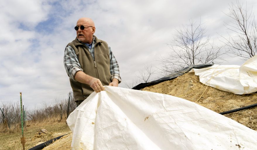 In this March 2019, photo, Mel Sword by his clay pile in Preston County, W.Va. He saved this clay while building his house. Sword practices an old kind of pottery technique — digging and processing his own clay, a practice of pottery that Appalachian’s ancestors did out of necessity for many years. (Caitlin Tan/West Virginia Public Broadcasting via AP)