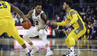 Providence&#39;s Luwane Pipkins (12) is defended by Marquette&#39;s Koby McEwen (25) and Markus Howard, right, during the second half of an NCAA college basketball game Saturday, Feb. 22, 2020, in Providence, R.I. (AP Photo/Stew Milne)