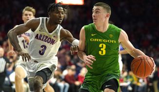 Oregon guard Payton Pritchard, right, drives on Arizona guard Dylan Smith during the first half of an NCAA college basketball game Saturday, Feb. 22, 2020, in Tucson, Ariz. (AP Photo/Rick Scuteri)