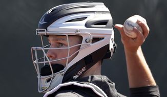 Baltimore Orioles catching prospect Adley Rutschman works with a pitcher during spring training baseball camp Saturday, Feb. 15, 2020, in Sarasota, Fla. (AP Photo/John Bazemore)