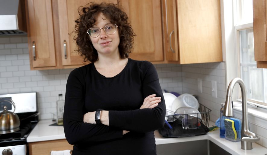 In this Wednesday, Feb. 12, 2020, Diana Betz, an assistant professor of psychology at Loyola University Maryland, poses at her home in Crofton, Md. Betz said, deciding who will fill out the questionnaire in the 2020 Census may force spouses or domestic partners to have conversations about their power dynamics that they might not have had for 10 years, the last time there was a decennial census. (AP Photo/Julio Cortez)