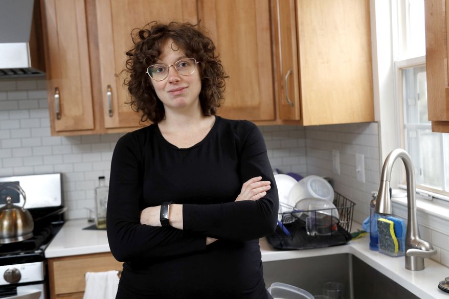 In this Wednesday, Feb. 12, 2020, Diana Betz, an assistant professor of psychology at Loyola University Maryland, poses at her home in Crofton, Md. Betz said, deciding who will fill out the questionnaire in the 2020 Census may force spouses or domestic partners to have conversations about their power dynamics that they might not have had for 10 years, the last time there was a decennial census. (AP Photo/Julio Cortez)